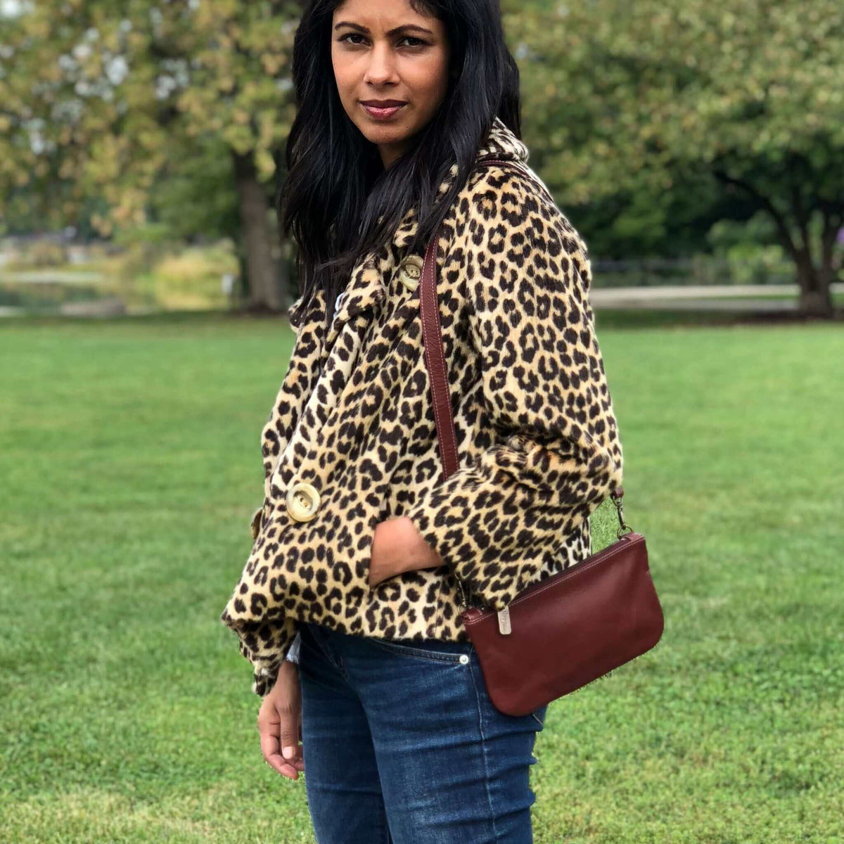 Cher mini crossbody shown as a shoulder bag in merlot with a leopard jacket