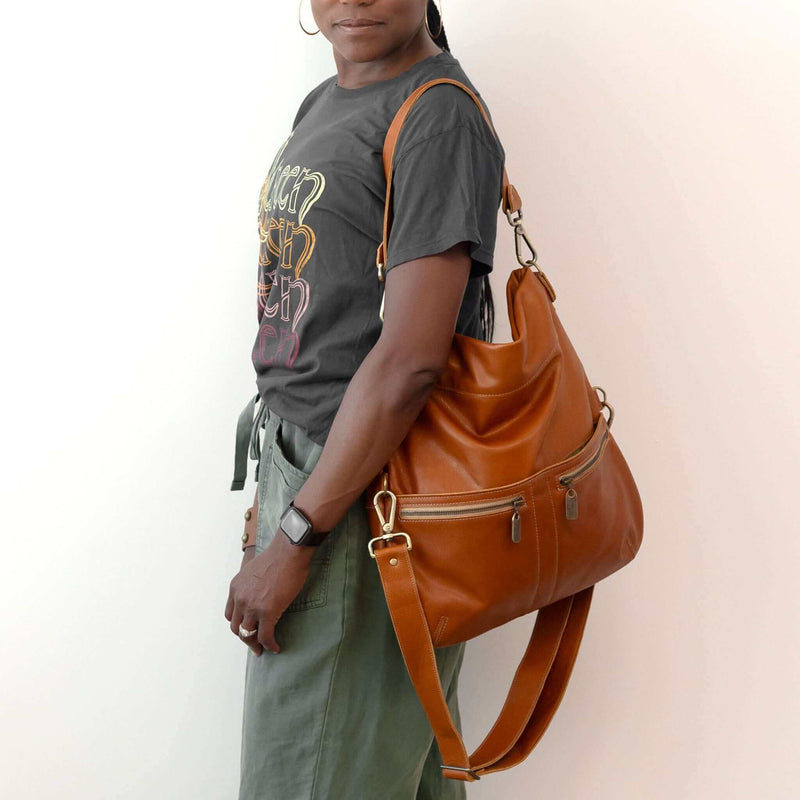 Woman wearing an Original Lauren leather crossbody bag in whiskey color, showcasing its stylish and versatile design.