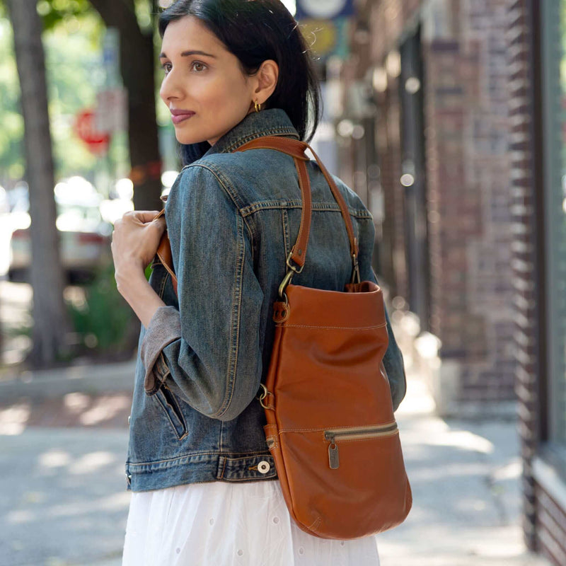 Model showcasing the Mini Lauren 6-in-1 convertible leather crossbody bag in whiskey color while wearing a denim jacket.