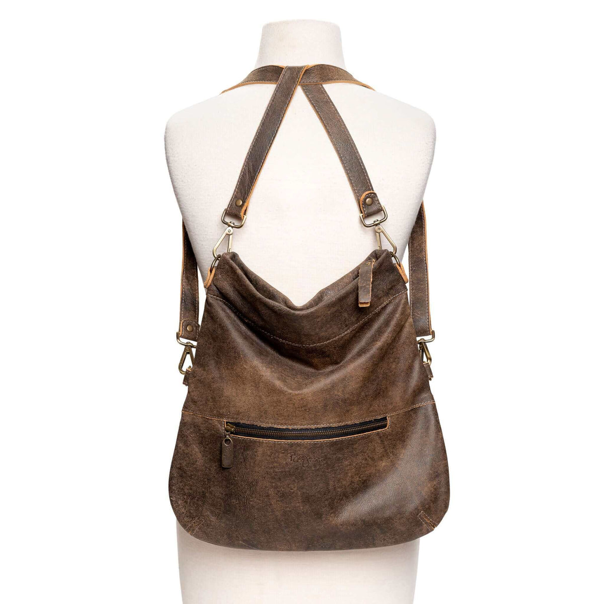 Brown leather handbag with a shoulder and crossbody strap, 6-in-1 convertible style leather crossbody bag. Shown as a backpack style.