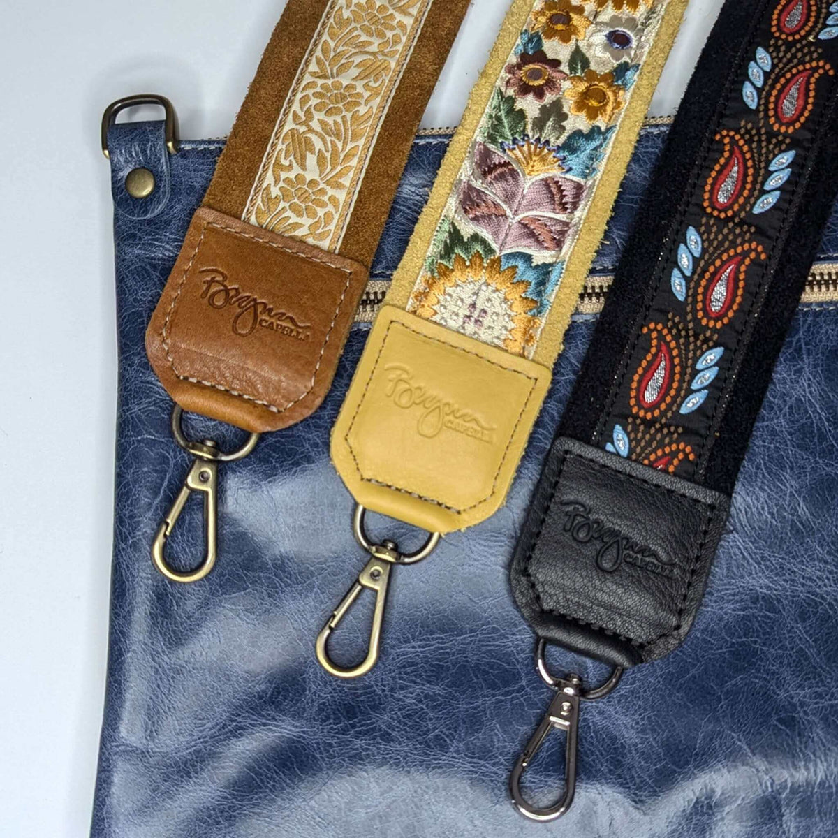 Three colorful guitar bag straps with leather trim, showcasing the Lizzy Guitar Bag Strap - Mustard Secret Vine design.