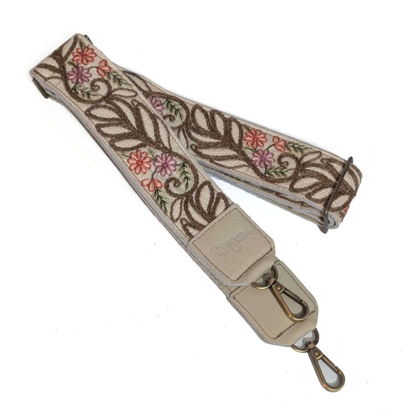 Floral embroidered strap with a metal clasp on a white background