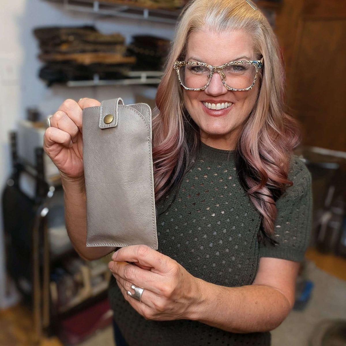 Woman holding an Allison Leather Eyeglass Case, showcasing its sleek design and functionality.