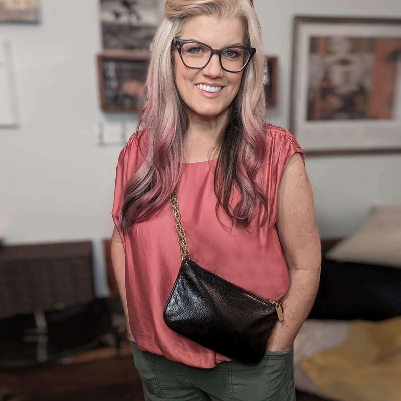 Woman wearing a metallic leather bag, showing its stylish design, perfect for casual or formal outfits.