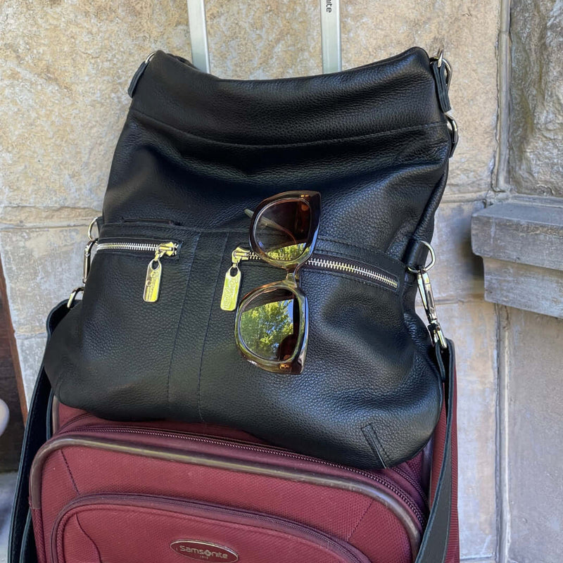 Original Lauren leather crossbody bag with sunglasses on top of a suitcase