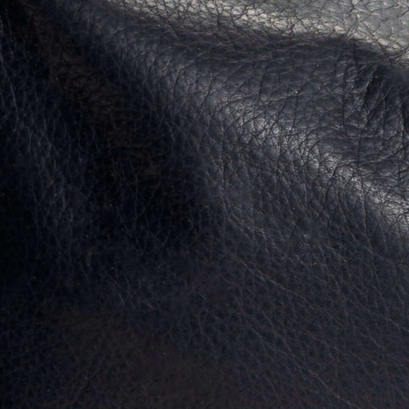 Close-up of the soft texture of original black leather crossbody bag material.