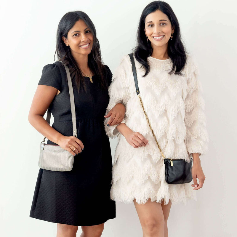 Two women showcasing metallic leather bags, dressed up for different occasions, highlighting the stylish Cher Chain Crossbody - Onyx.