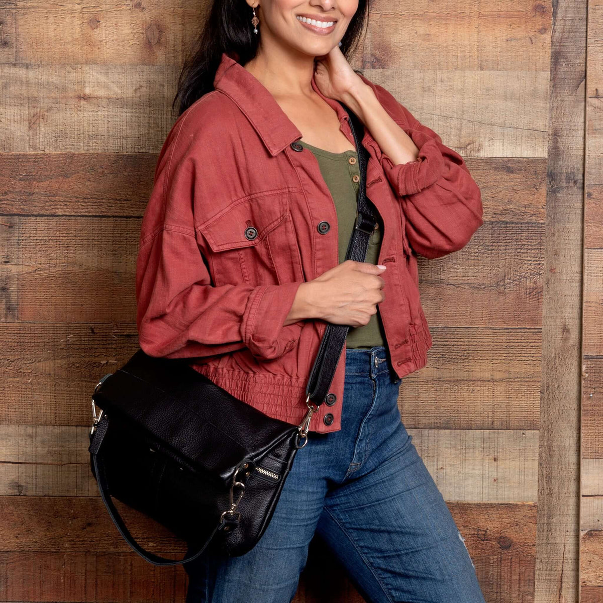 Woman in casual outfit holding the Mini Lauren 6-in-1 Convertible Leather Crossbody Bag - Noche.