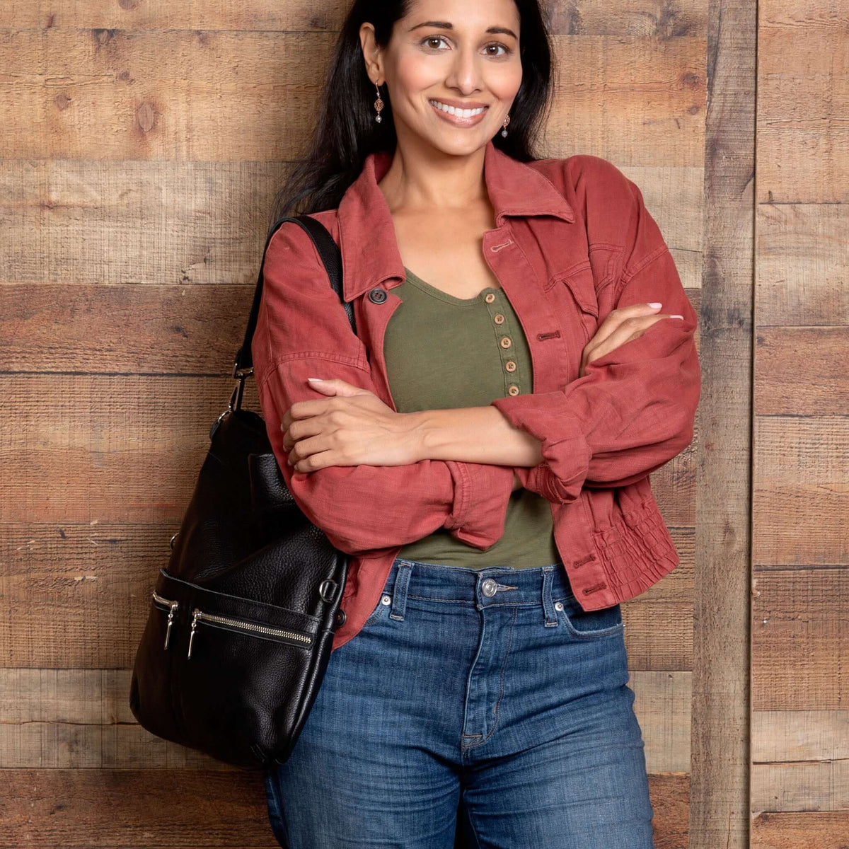 Woman in casual outfit holding the Mini Lauren 6-in-1 Convertible Leather Crossbody Bag - Noche. Shown full length.