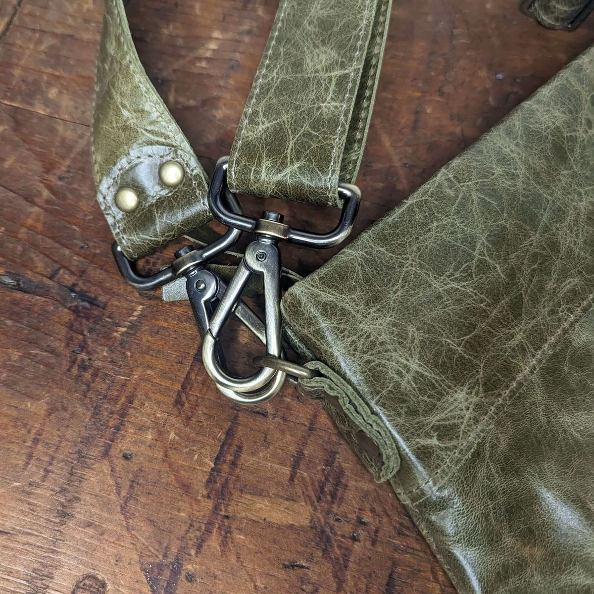 Close-up of the strap and clasp of the Original Lauren leather crossbody bag in olive green.