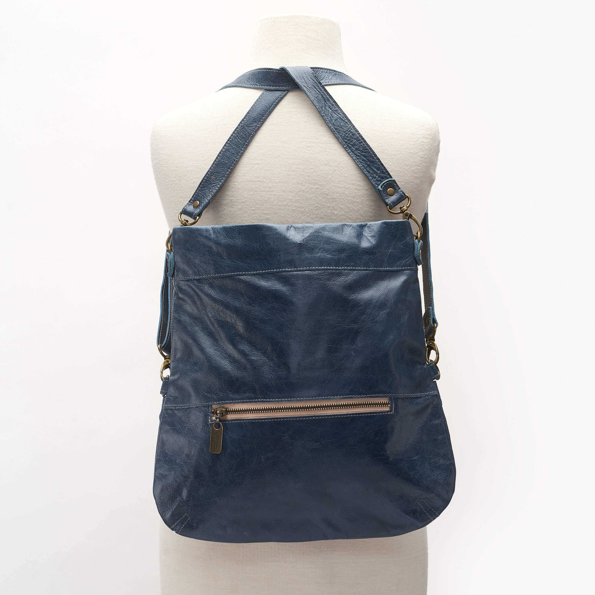 Backpack view of Mini Lauren leather crossbody bag in navy showing adjustable straps and zipper pocket.