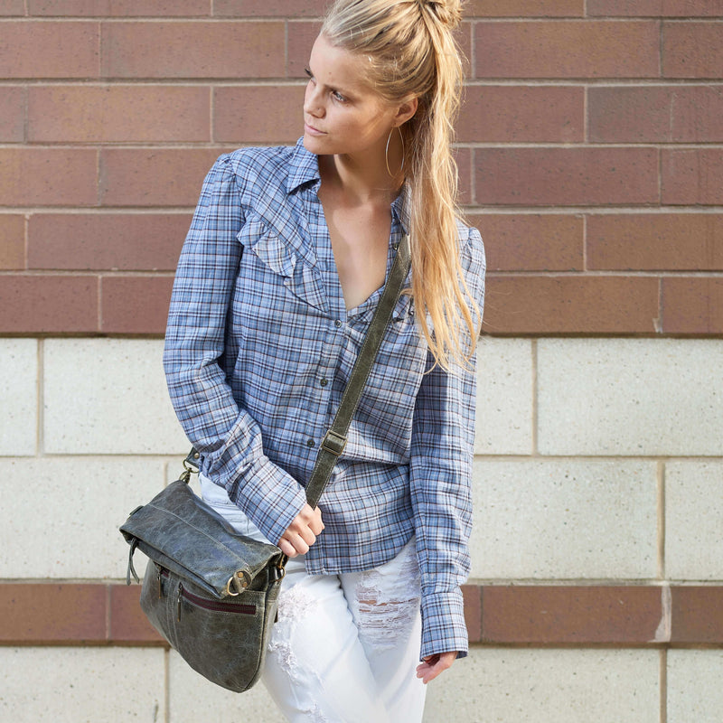 Woman wearing a plaid shirt and white jeans, carrying a Mini Lauren 6-in-1 convertible leather crossbody bag in River Rock.