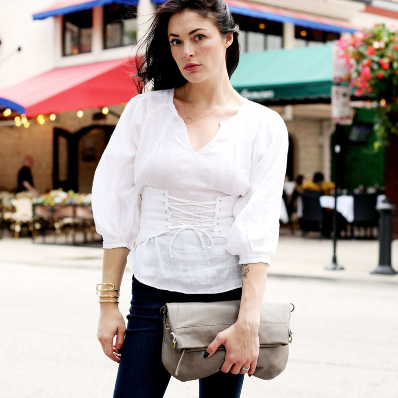 Model holding Mini Lauren 6-in-1 Convertible Leather Crossbody Bag - Stone Temple while wearing a stylish white blouse.