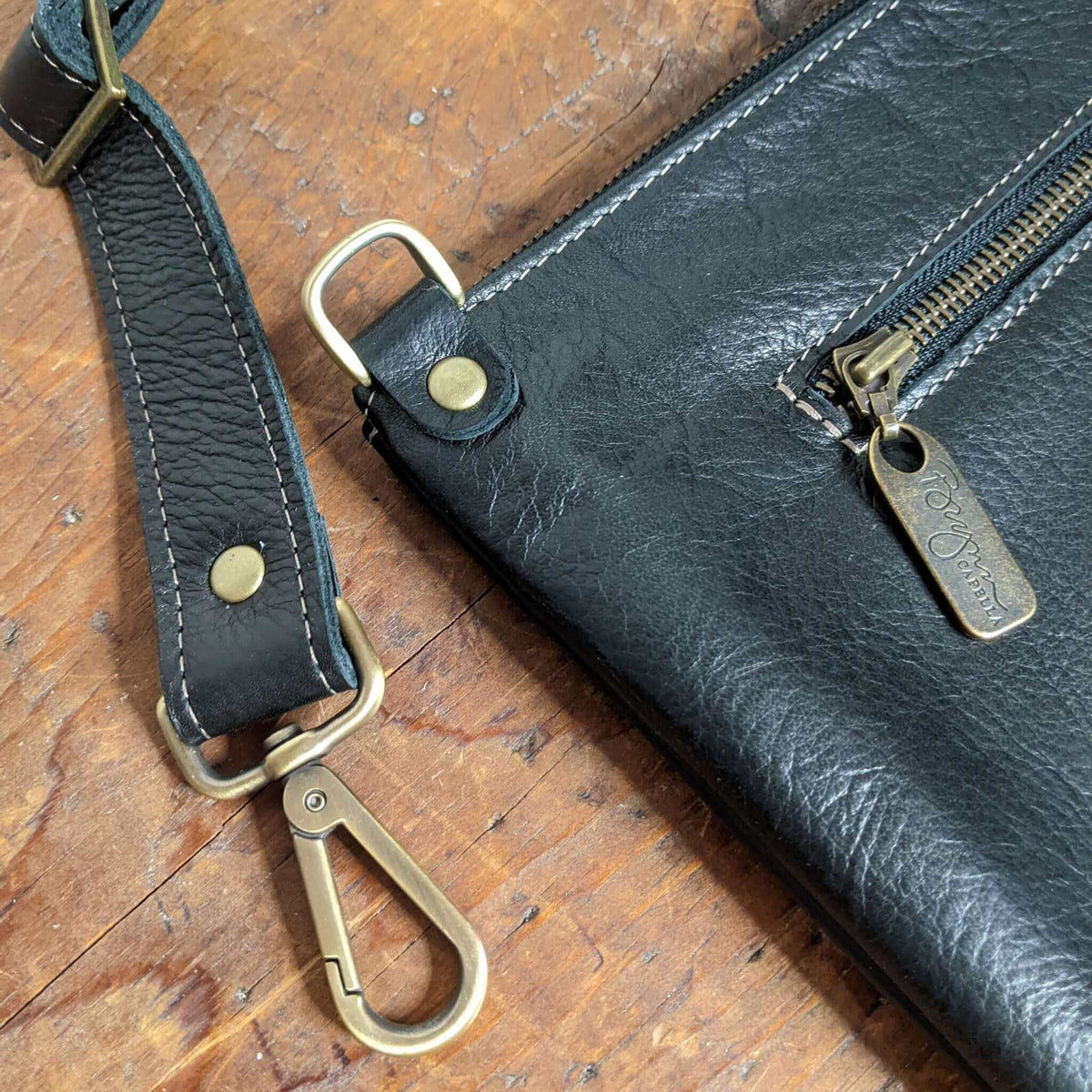 hardware hightlight of Studded bag in black full-grain leather convertible clutch-to-crossbody with adjustable strap