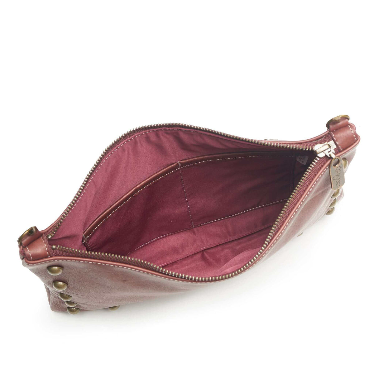 Interior of studded crossbody bag in wine full-grain leather, small crossbody bag showing lining and pockets